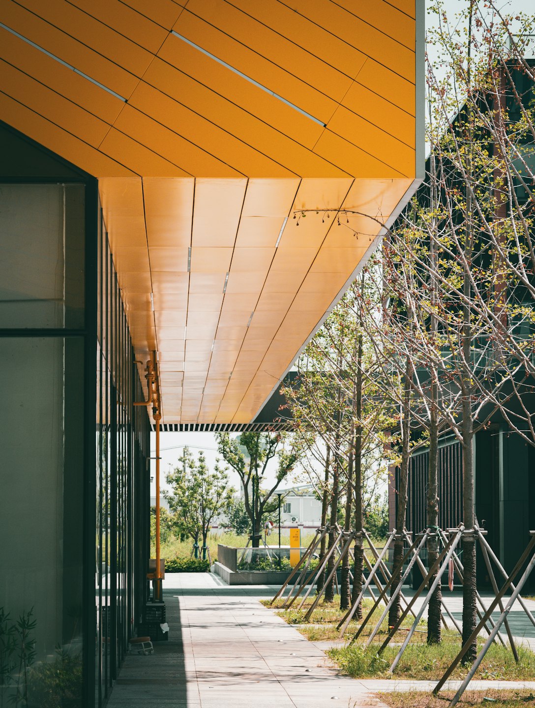 Modern building with a bright yellow facade and glass panels.